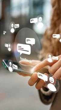 User interacts with a smartphone while viewing feedback icons in a busy urban Stock Photos