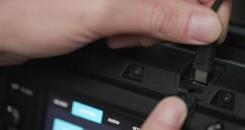 The user precisely plugs a usb-c cable into the side of a sleek. Stock Photos