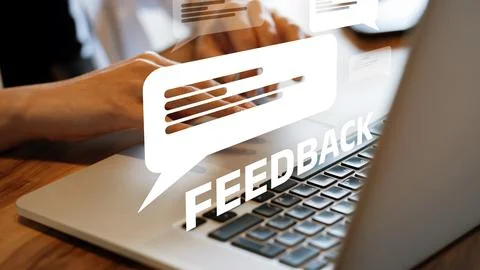 User provides feedback while typing on a laptop in an office environment Stock Photos