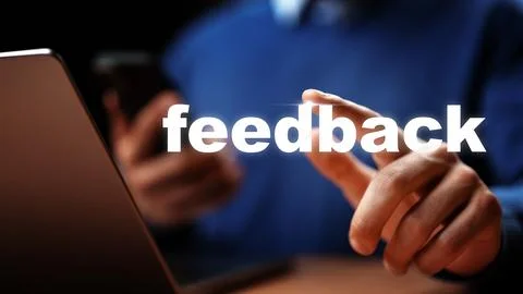 User providing feedback while using a smartphone and laptop in a workspace Stock Photos