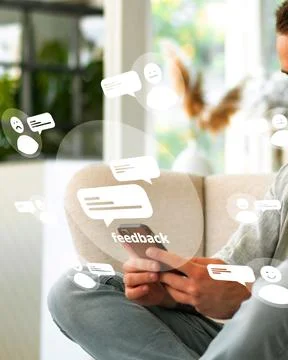 User reading and responding to feedback while sitting indoors in a comfortable Stock Photos