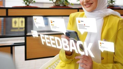 User reading feedback on a mobile phone in a modern setting with speech bubbles Stock Photos