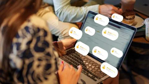 User receives feedback while working on a laptop in a cafe during the day Stock Photos