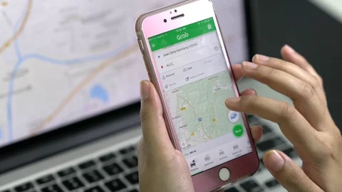 User Searching for location in GrabCar App. Grabcar is famous for its logistics Stock Footage 77198325