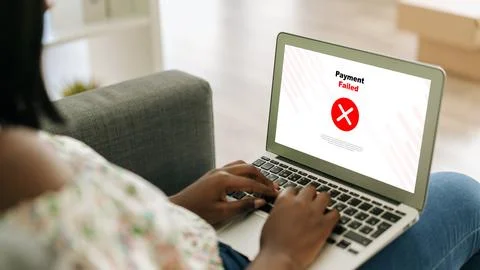 User sees payment failed message on laptop while sitting on sofa at home 库存照片