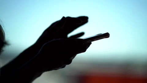User of social nets is swiping screen of modern smartphone, silhouette closeup Stock Footage 137086931