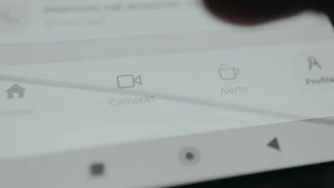User taps the Cameras option from smart home security application to access live Stock Footage 333379431