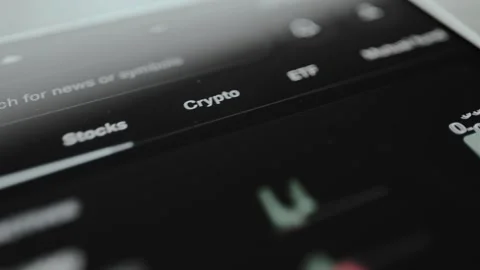 User taps the Crypto asset class within a user interface of a financial Stock Footage 329772584