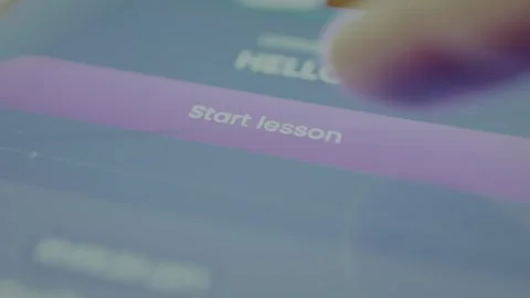 User taps the digital button labeled START LESSON within a mobile app interface Stock Footage 328355921