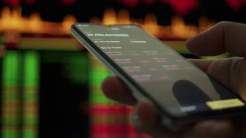 User trading crypto currency coin stocks on smartphone app Stock Footage 167656269