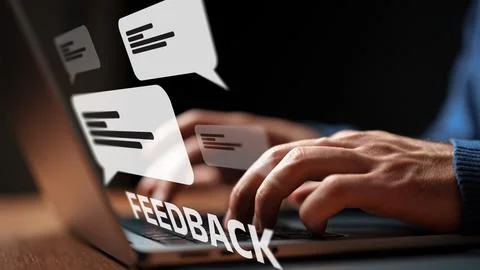 User typing feedback on a laptop with chat bubbles in the background Stock Photos