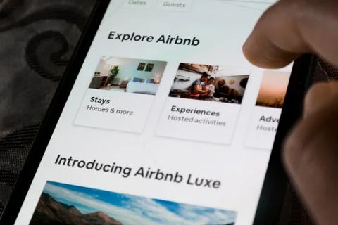 A user using the Airbnb app on a smartphone - exploring travel destinations Stock Photos