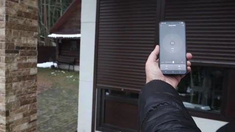 Users hands open door gate and press pause using smart home mobile app, right Stock Footage 326964698