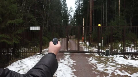 Users hands open outdoor gate with remote, front view Stock Footage 326965615