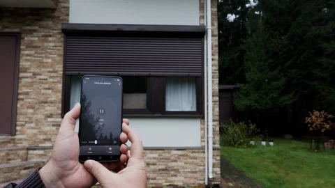 Users hands open Rolling Shutter Window using smart home mobile app and stop 動画素材 326967189