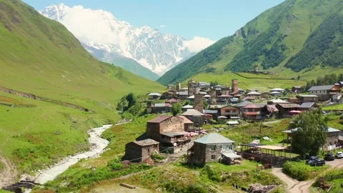 Ushguli settlement approaches in forward aerial view beside the Enguri River and Vídeo Stock 343542484