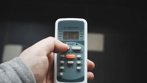 Using air conditioner remote control closeup. Setting an air conditioner at a 스톡 동영상 90540617