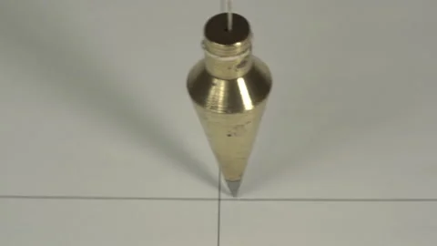 Using an antique plumb bob to find the exact center Stock Footage 202147558