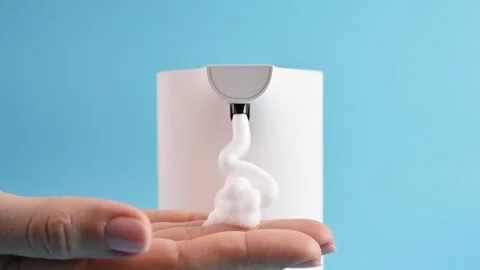 Using automatic soap dispenser. Young girl woman brings her hands to dispenser Vidéo 170047969