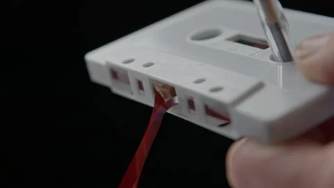 Using a Ballpoint Pen to Wind Slack Magnetic Tape Back Into an Audio Cassette Stockbeeldmateriaal 290046451
