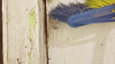 Using a blue bristle brush to clean dirty spider webs and thick dust on the.. Stock Footage 324822881