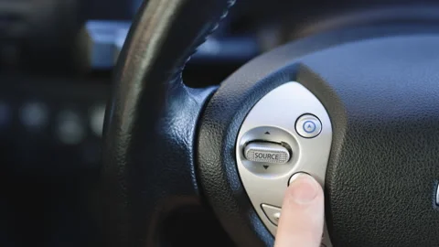 Using the Bluetooth buttons located on the steering wheel of a car to talk over Video stock 196003021
