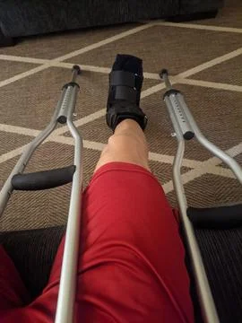Using a boot and crutches after a fracture Stockfoto's