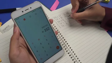 Using calculator on phone to do math Stock Footage 276807972