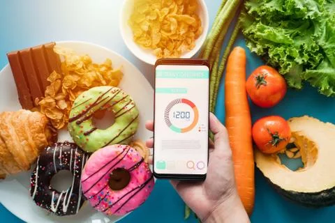 Using Calories counting application on her smartphone for food control Stock Photos