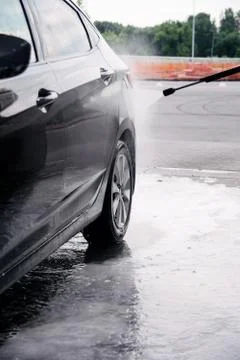 Using a car wash, wash off detergent from a gray car with water Stock Photos