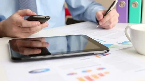 Using cell phone and writing notes Stock Footage 22008778