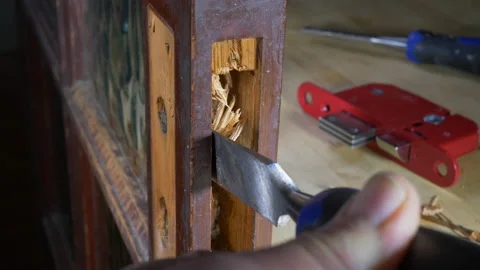 Using a chisel on a door mortice to fit a new lock. Stock Footage 138234654