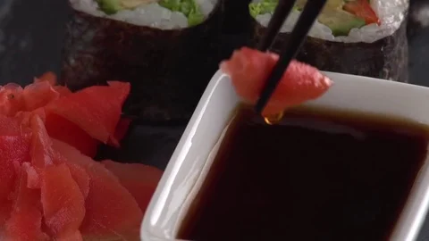 Using chopsticks to dip sushi into soy sauce, Japanese Food Stock Footage 84824657