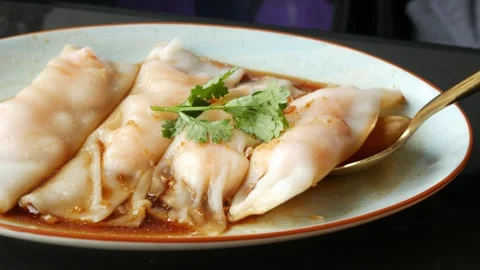Using chopsticks for eating steamed BBQ pork rice noodle rolls in chinese r.. Stock Footage 297456699