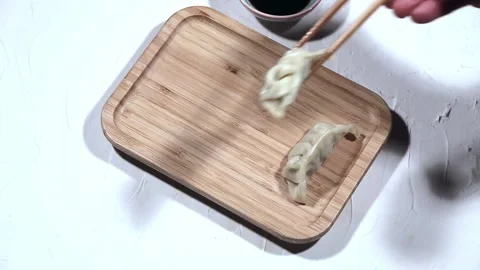 Using chopsticks to serve fried balls. Portions of delicious gyoza served at Stock Footage 144246693