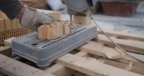Using circular saw, bricklayer easily cuts brick into pieces, evens edges of cut Stock Footage 116814473