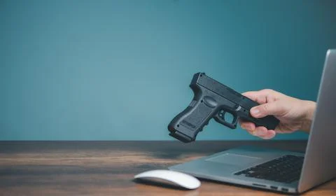 Using computer buying handgun from online seller shop. Stock Photos