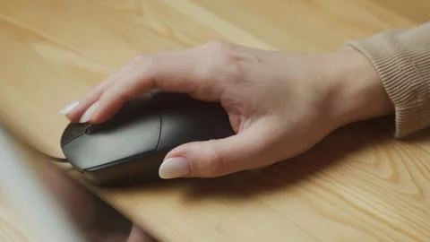 Using a computer mouse for work at a desk with a wooden surface during daytime Stock Footage 303768437