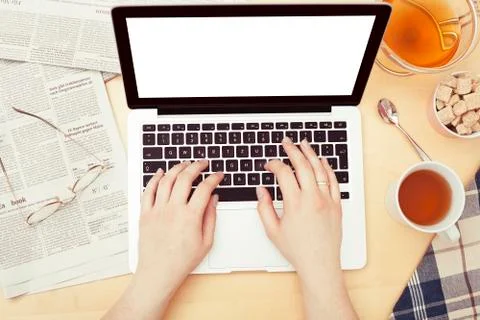 Using a computer while drinking tea Foto stock