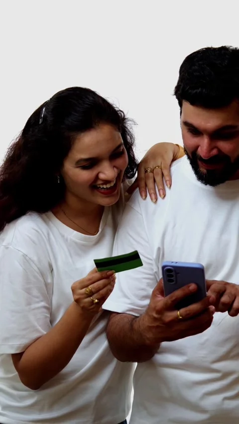 Using credit card, Indian couple smiles while shopping online with mobile Stock Footage 343163965