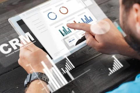 Using CRM software on a tablet to analyze customer data and performance metrics Stock Photos