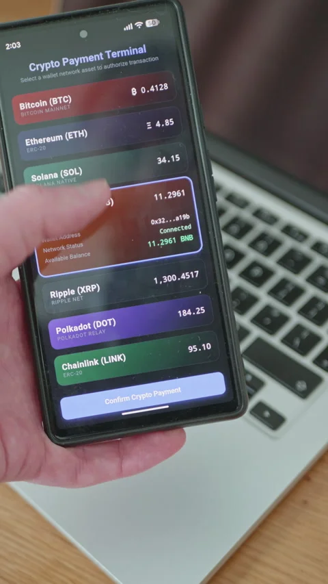 Using a crypto payment terminal app on a mobile phone next to a laptop Stock Footage 335528840