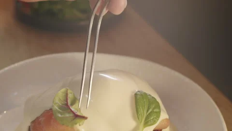 Using culinary tweezers gently put green watercress leaves to the brioche toast  스톡 동영상 150964123