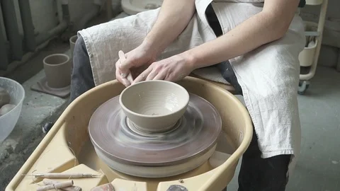 Using damp sponge potter shapes bowl on the potter's wheel. Stock Footage 87333421