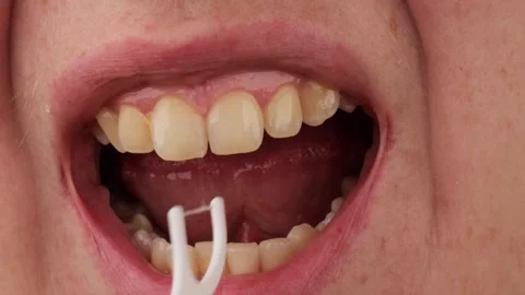 Using dental floss pick. cleaning teeth with floss tool. oral hygiene routine Stock Footage 323331896