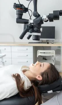 Using dental microscope treating patient teeth at dental clinic office. Medicine Stock Photos