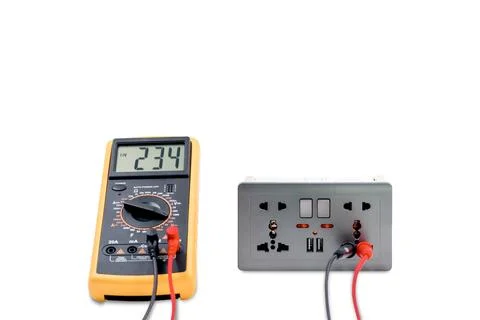 Using a digital meter to measure the voltage at an electric outlet socket b.. Stock Photos