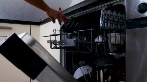 Using a dishwasher. Close-up of a woman's hands retrieving a dishwasher basket  Stock Footage 277950397
