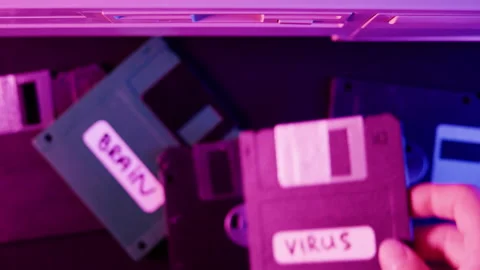 Using diskette with virus close-up. Old floppy disk, disc drive top view. Retro Stock Footage 205901324