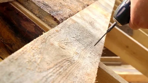 Using drill to attach long board to the bolster. Assembling house roof Video stock 74734356